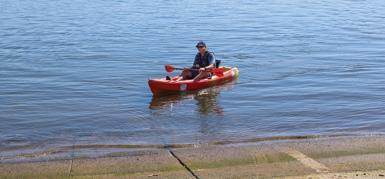 Long-distance canoeist Neal Moore brings a kayak to shore at the Paducah, Ky., riverfront on August 17 after a brief paddle around Owens Island at the confluence of the Ohio and Tennessee rivers with Jeff Canter of the Tennessee Riverline initiative. (Photo by Shelley Byrne)