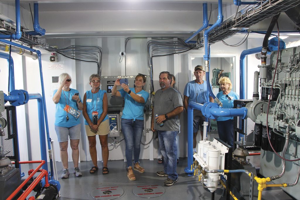 Members of the Lower Kaskaskia Stakeholders Inc. in blue shirts take a tour of the boat’s engineroom. (Photo by David Murray)