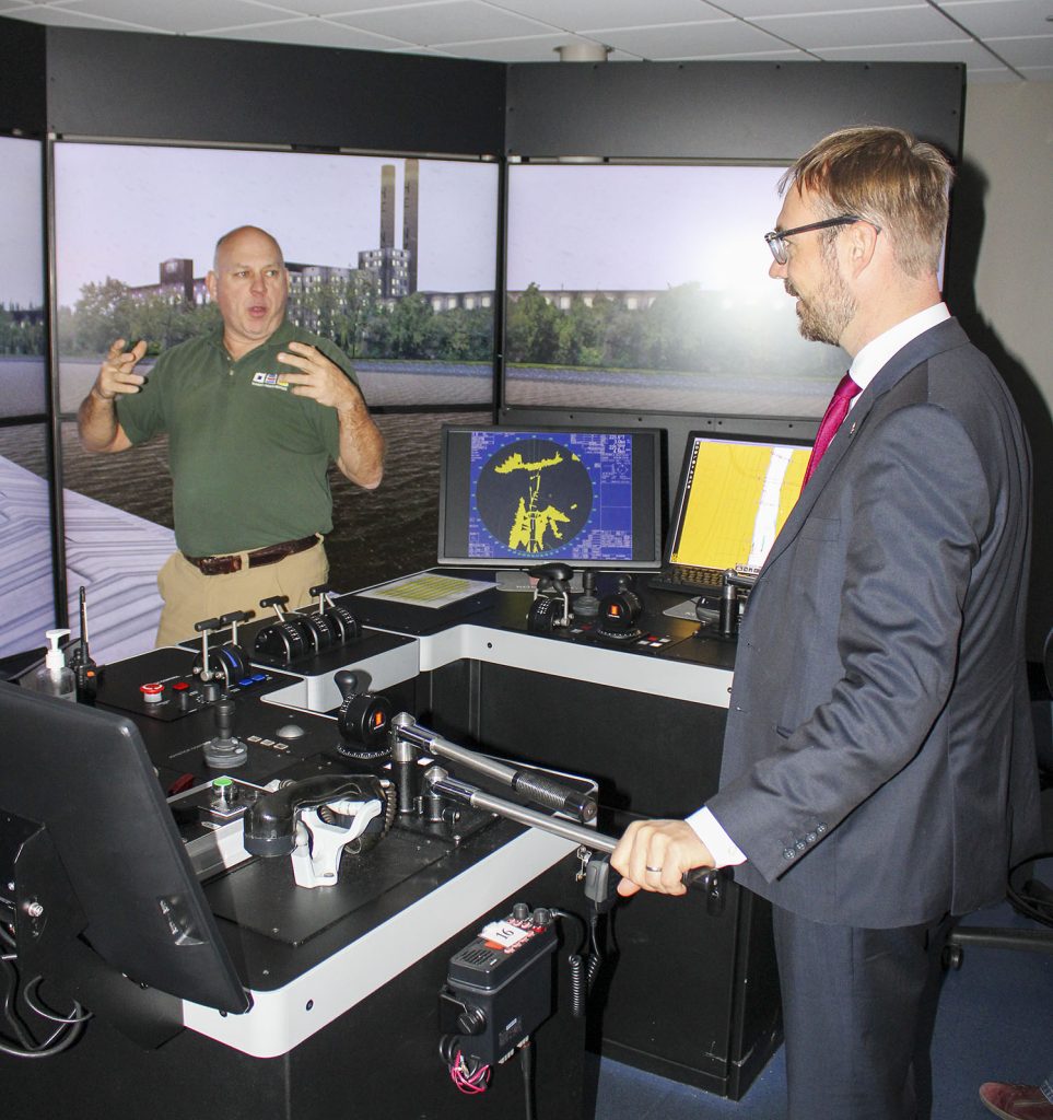 Dr. Joachim Eichhorn, one of the members of visiting group representing the German Ministry of Transport, takes his turn piloting a simulated towboat traveling through Pittsburgh, Pa., as SCI’s John Arenstam helps to guide him. (Photo by Shelley Byrne)