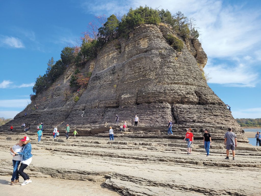 Crowds of people have been visiting Tower Rock in Perry County, Mo., especially on the weekends. The low water has made visiting the landmark island in the Mississippi River accessible by a natural limestone bridge. The Missouri Department of Conservation, which bought the 32-acre island in 1973, is urging people to be safe and courteous when visiting. According to the Missouri Department of Conservation, the geological formation is about 400 million years old and topped with an upland oak-pine and mixed hardwood forest. It was listed on the National Register of Historic Places in 1970. The rock is also known as Grand Tower. The rock is 1 mile south of Wittenburg, Mo., across the river from Grand Tower, Ill. The earliest mention of the island by Europeans is by the French missionary Jacques Marquette in 1673. Explorer Meriwether Lewis of the Lewis and Clark Expedition also mentioned the island in his journals, saying that rivermen who passed the rock would celebrate in a way similar to sailors crossing the equator, by raising their glass in a toast. (Photo by Jeffrey Seay)