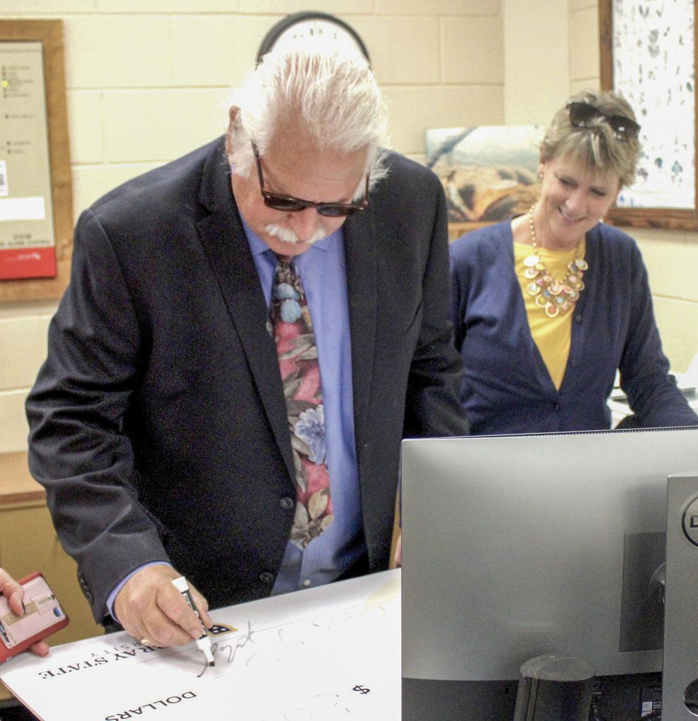 Capt. Bob Cherry signs a $500,000 check representing his donation to Murray State University’s Hancock Biological Station on the banks of Kentucky Lake in western Kentucky as Jennie Rottinghaus, the director of development for the College of Science, Engineering and Technology and the School of Nursing and Health Professions, looks on. (Photo by David B. Snow/The Paducah Sun - Reprinted by permission.)