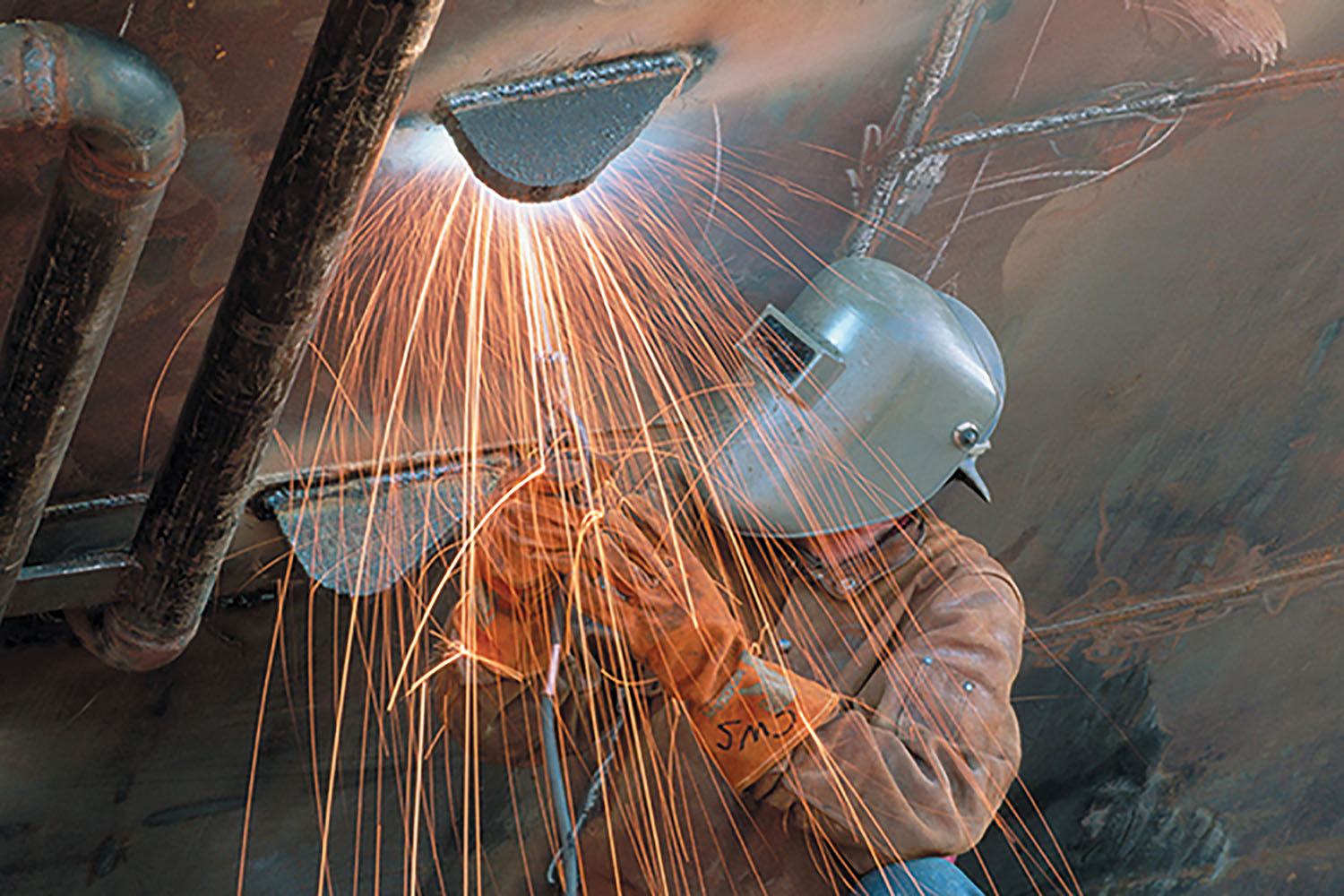 One of Tradesmen International’s craftworkers welds on the hull of a vessel at a shipyard.