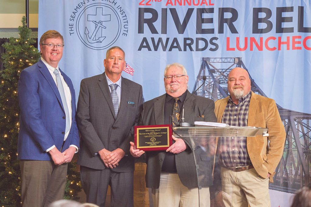 Lifesaving Award presented by Russ Lampkins, senior vice president–logistics/customer service, Ingram Barge Company (left) to the crew of the Michael J. Grainger: Capt. Mike Hughes, Capt. Joe Young, and Senior Mate Mike White. Senior Deckhand Jason Lovell was also on watch, but was unable to make the ceremony. (Photo by Brad Rankin, courtesy of Seamen's Church Institute)