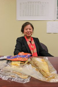 Angie Yu, president of Two Rivers Fisheries, shows some of the prototype products being developed from carp being processed at her facility in Wickliffe, Ky. They include salt carp and smoked salt carp for the Caribbean as well as fish jerky dog treats. (Photo by Shelley Byrne)