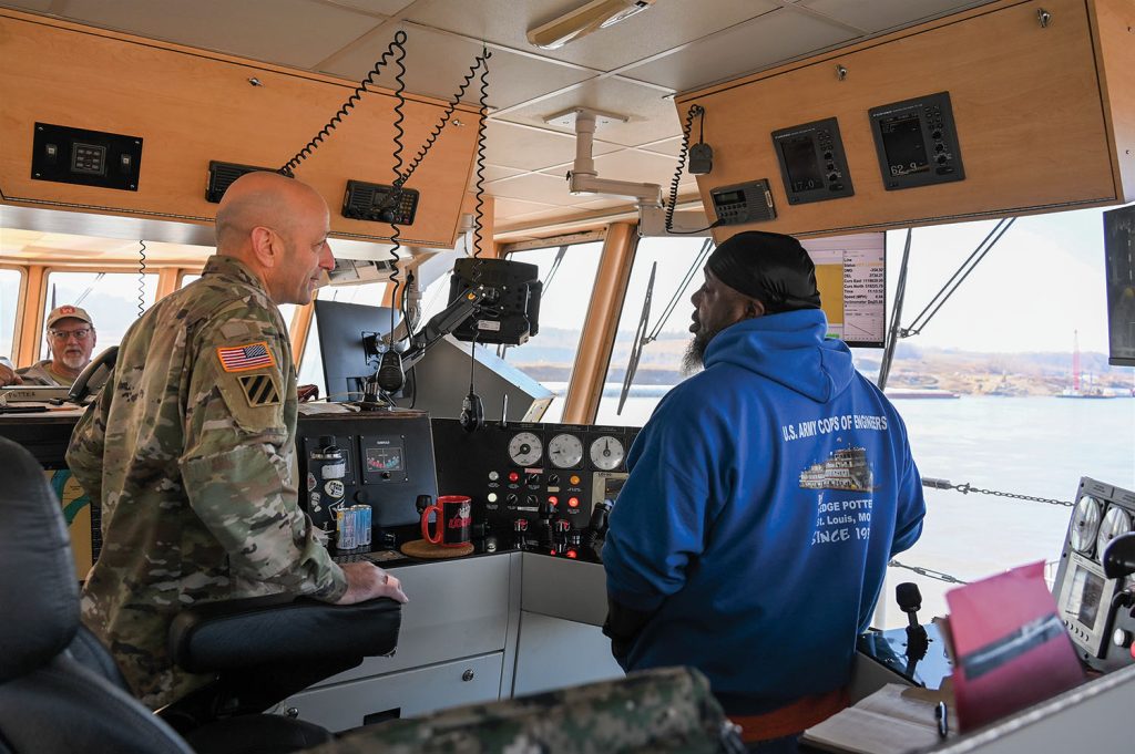 Lt. Gen. Scott Spellmon listens as dredge equipment operator James Garner explains his position, which consists of controlling the pump, running the winch lines and guiding the dredge through the cuts. (Corps of Engineers photo by George Stringham)