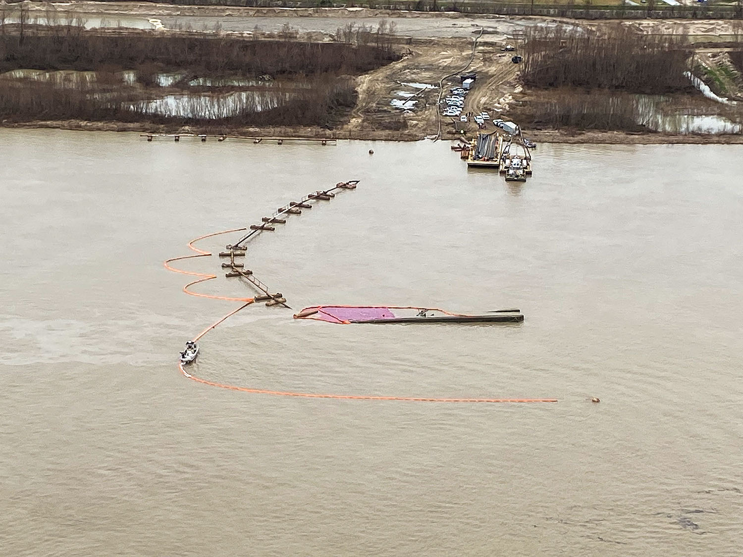 An aerial shot of the W.B. Wood after it capsized on the Mississippi River with 940 feet of boom around it near Meraux, La., on January 16. The Coast Guard Sector New Orleans Incident Management Division is overseeing the pollution response and coordinating with Wood Resources LLC on plans to salvage the capsized vessel. (U.S. Coast Guard photo by Sector New Orleans)