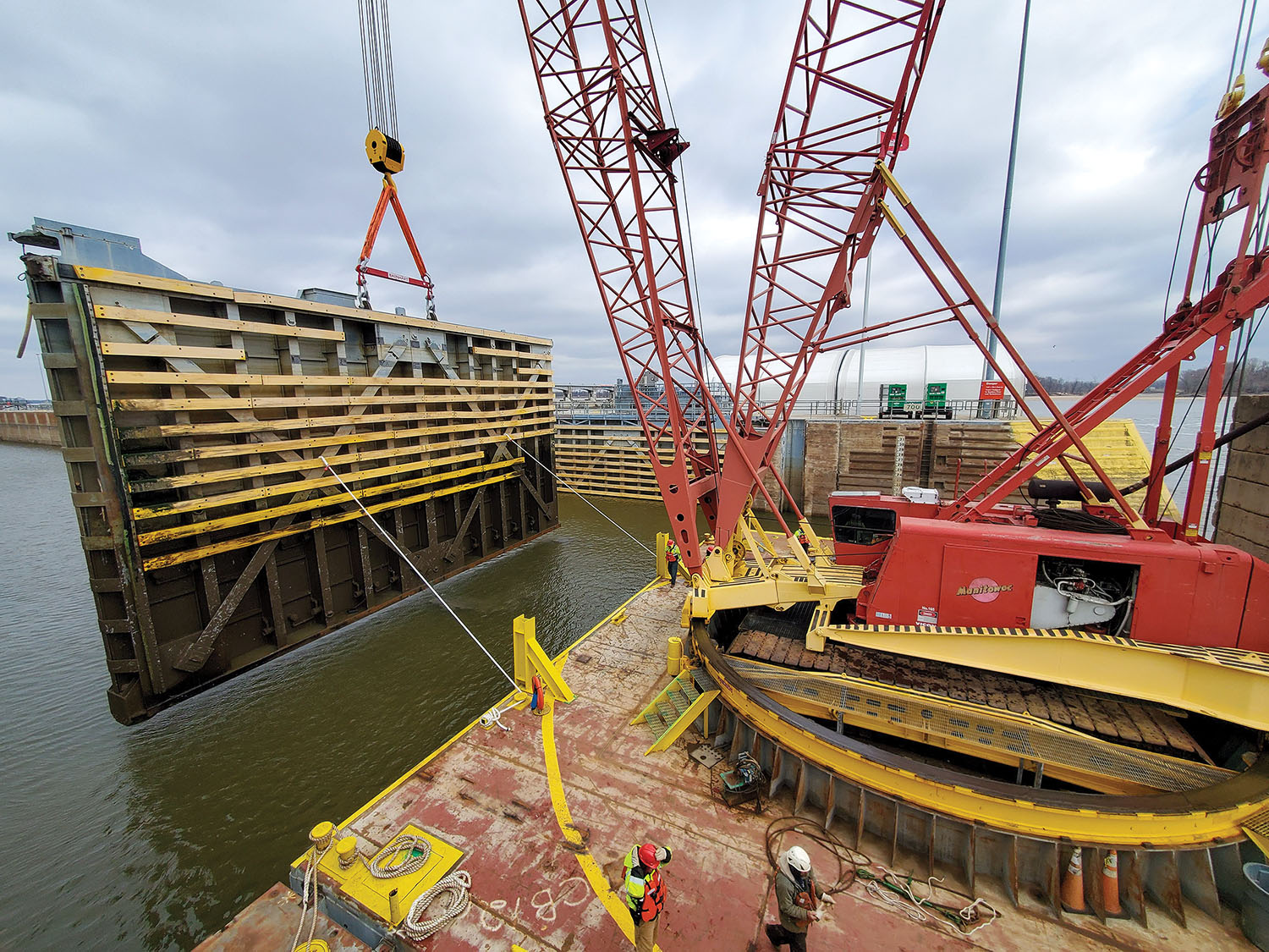 One of the two 230,000-pound miter gates is pulled January 17 by Massman Constructors’ 350-ton crane barge so maintenance crews can install new seals and conduct other work. (Photo courtesy of St. Louis Engineer District)