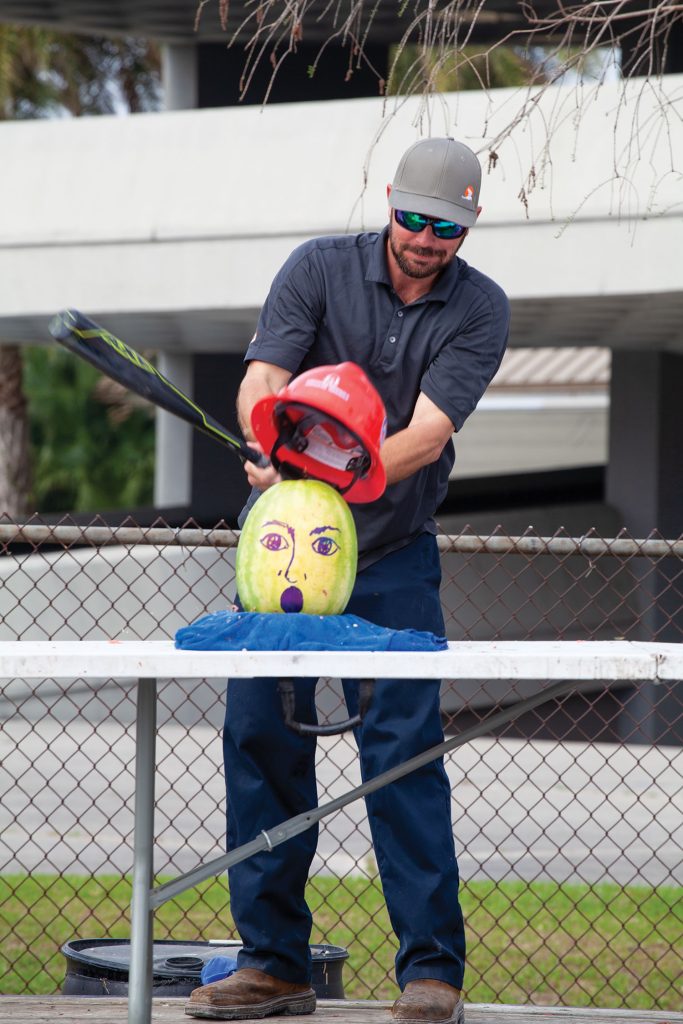 Lloyd Trosclair of Turn Services uses a baseball bat and a watermelon to demonstrate the importance of wearing proper safety equipment. (Photo by Frank McCormack)