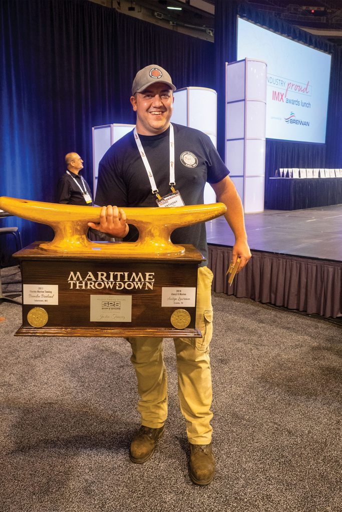 2022 Maritime Throwdown champion Anthony Pettry of Amherst Madison hefts the winner’s trophy, which was created by Nabrico/Wintech/Arcosa. (Photo by Lauren Gosling)