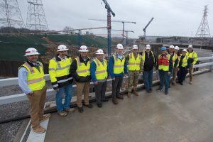 U.S. Army Corps of Engineers Nashville District officials and stakeholders pose for a group photo on top of the cofferdam during a tour of the active Kentucky Lock and Kentucky Lock Addition Project on the Tennessee River in Grand Rivers, Kentucky. (USACE photo by Lee Roberts)