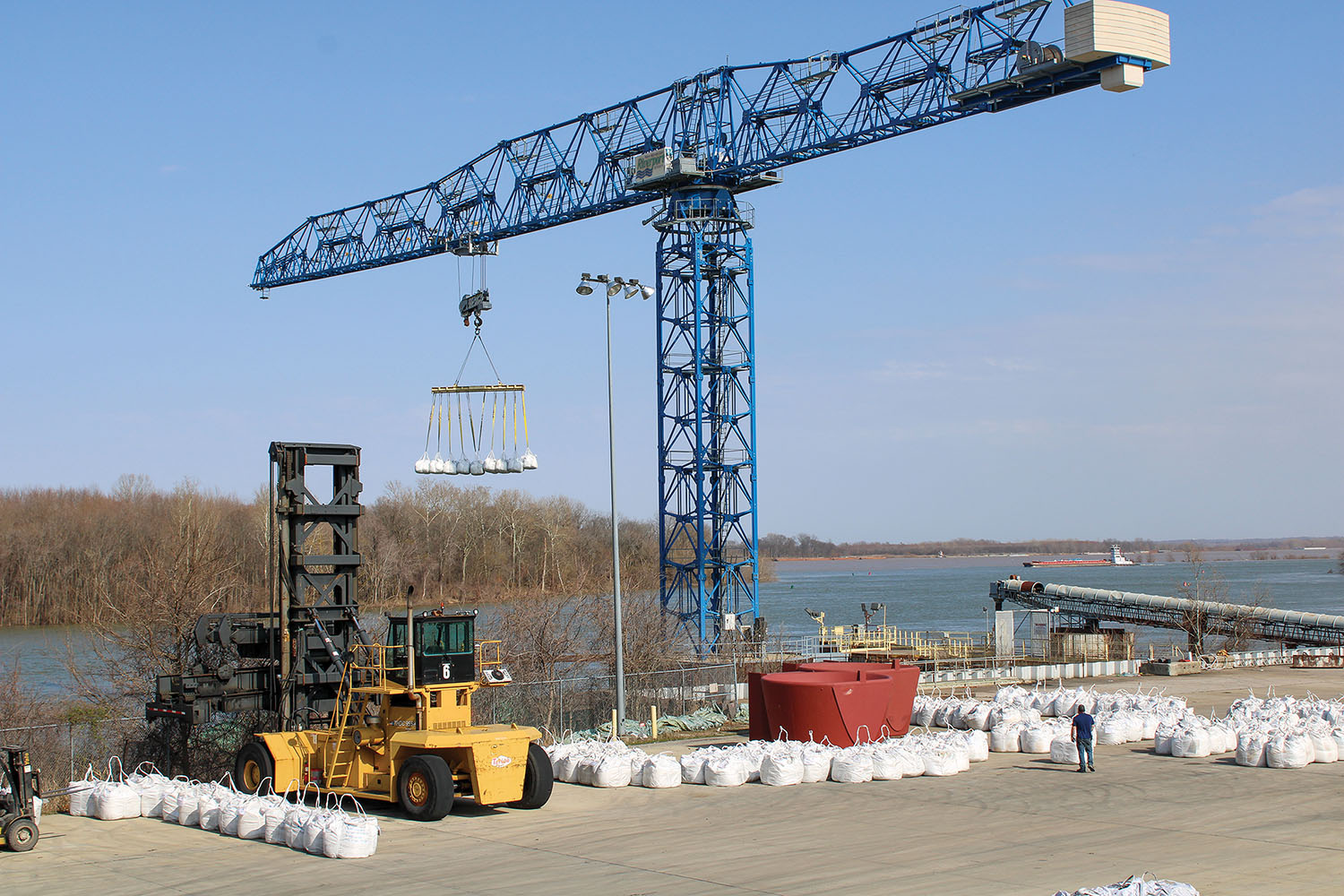 The Paducah-McCracken County Riverport Authority’s 53-ton lift Comansa tower crane unloads a barge full of supersacks filled with raw materials for new customer PRCO America Inc. (Photo by Shelley Byrne)