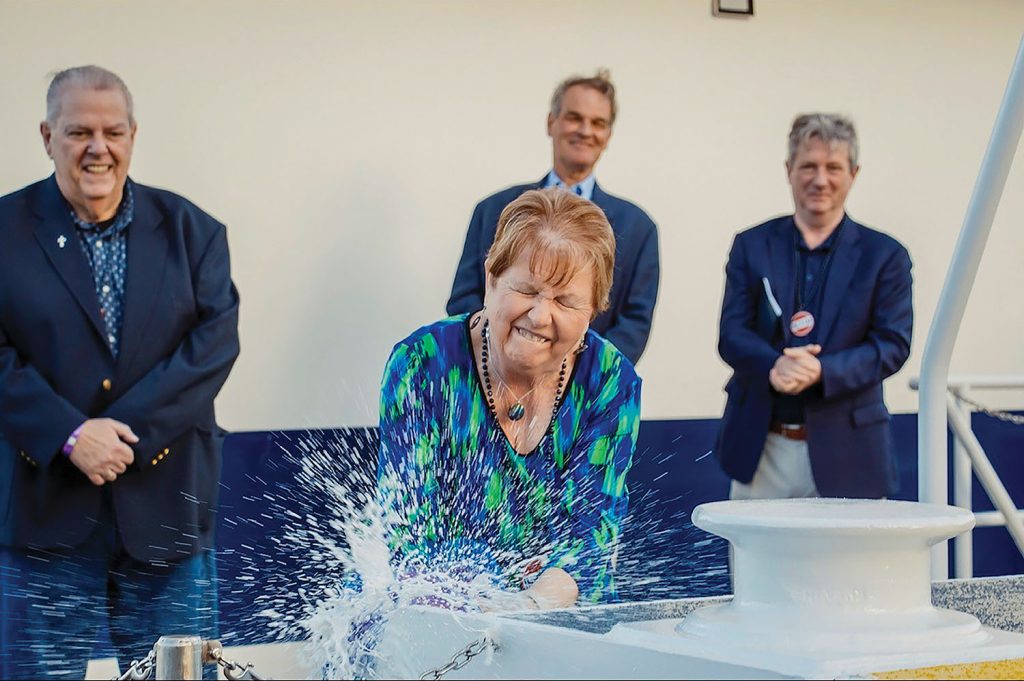 Michelle Alley breaks a champagne bottle on the push knee of the mv. Steve Alley. Looking on are her husband, Steve Alley; Orrin Ingram; and John Roberts. (Photo courtesy of Ingram Barge Company)