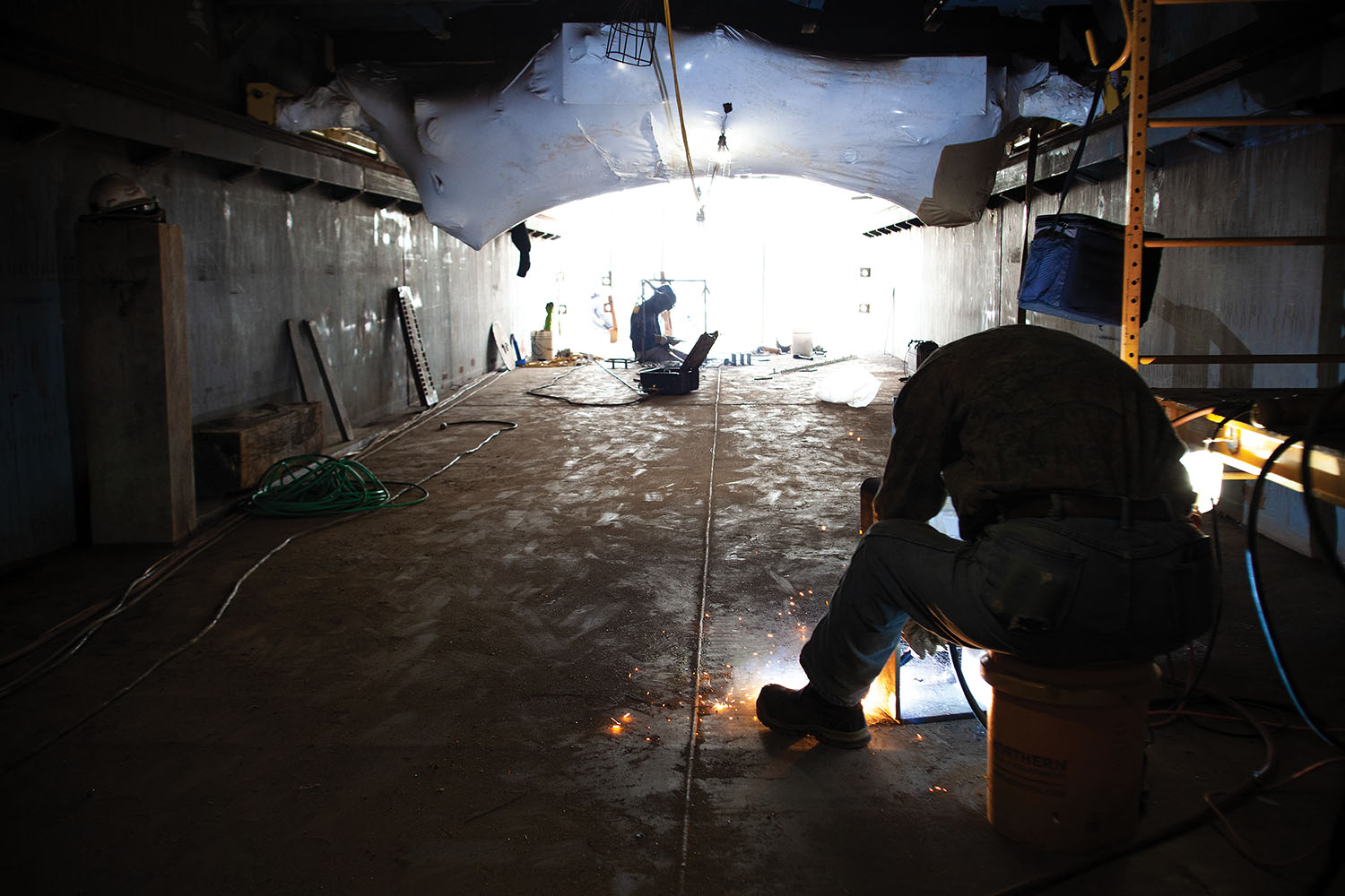 A pair of welders at Thoma-Sea’s shipyard in Lockport, La., work in the hull of ARMOR 1, the U.S. Army Corps of Engineers’ forthcoming replacement to the venerable Mat Sinking Unit, commissioned in 1948. (Photo by Frank McCormack)