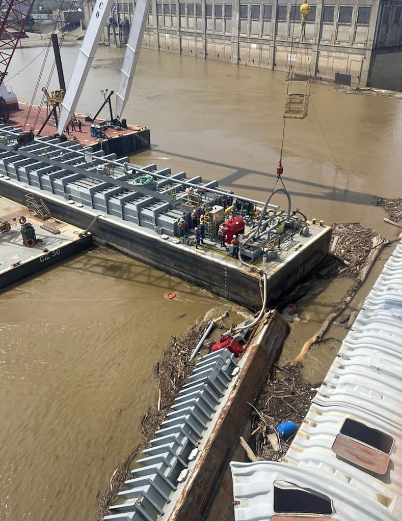 Crews work to remove methanol barge from dam. The barge was successfully lightered and removed with no leaks. (Photo by Jay Rickman, U.S. Army Corps of Engineers)