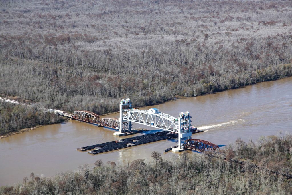 A barge tow passes under the vertical lift span at the Mile 14 Bridge over the Mobile River near Hurricane, Ala. (Photo courtesy of Scott Bridge Company)