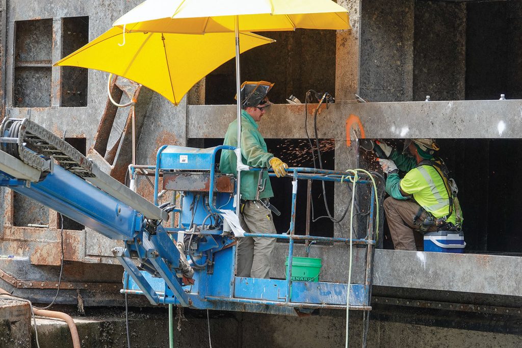 Crews grinding the upbound gates in prep for weld repairs. )Photo by Paul Rohde, Waterways Council Inc.)