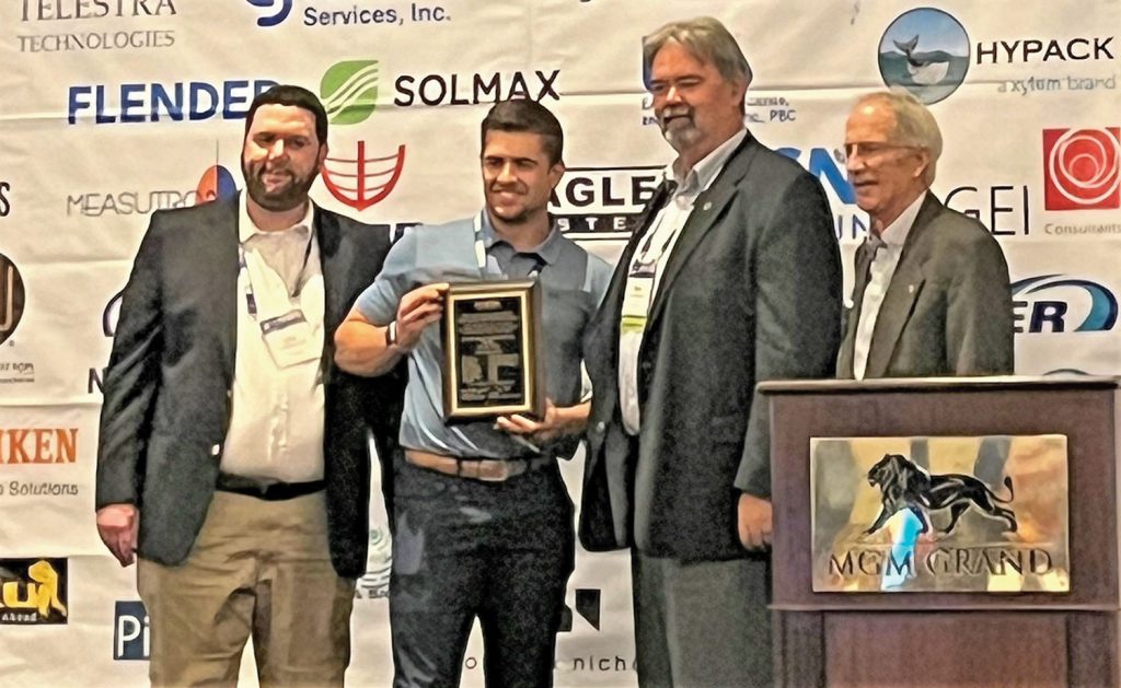 Nick Chycko accepts the Environmental Excellence Award for Innovation on behalf of J.F. Brennan Company.  He is an assistant project manager for Brennan, working at the Howards Bay Project, and drafted the award submission. (Photo by Judith Powers)