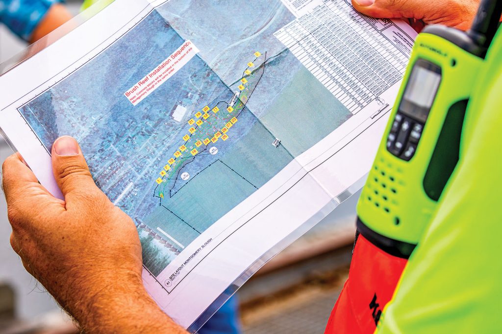 A contractor for the Corps looks at a map showing locations where a helicopter will place tree bundles to create fish habitats. (Photo by Michel Sauret/Pittsburgh Engineer District)