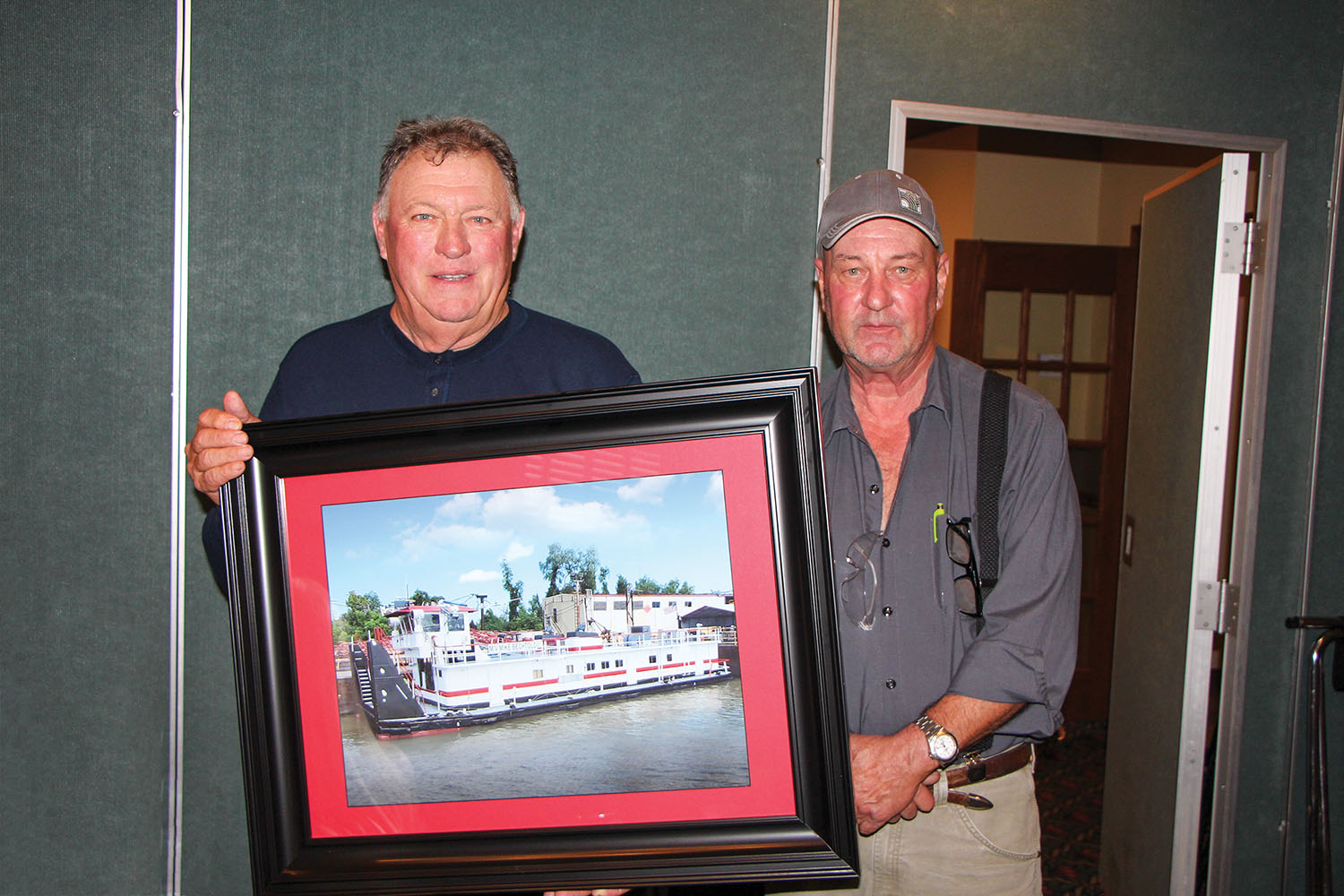 Mike Bechtold, left, receives a photo of the towboat newly renamed in his honor from Bruce McGinnis. (Photo by Zac Metcalf)