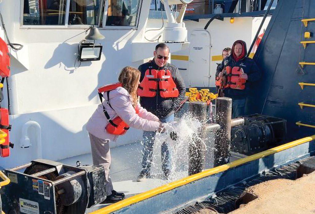 Ava Renee Ozinga breaks the bottle to christen the Ava Renee. (Photo courtesy of Middle River Marine)