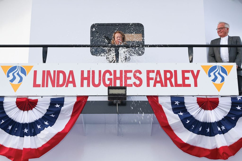 Linda Hughes Farley breaks a champagne bottle to christen the vessel named in her honor, while her husband, Jim Farley, looks on. (Photo courtesy of Campbell Transportation Company)