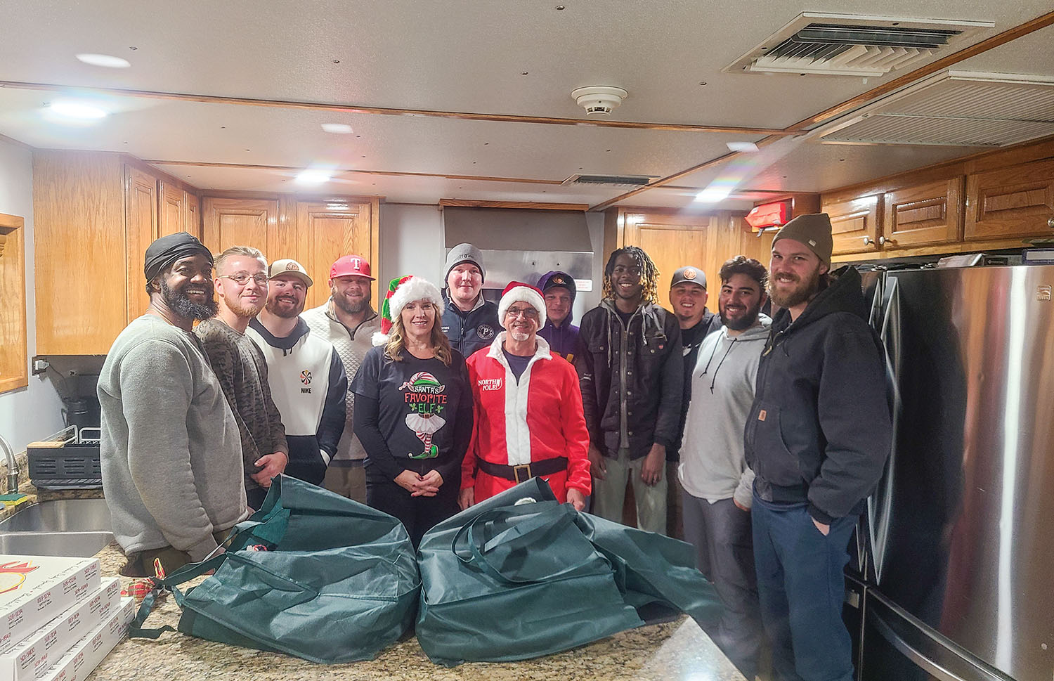 The crew of the mv. Shelby Gros—Capt. Jonathan Gilliland, pilot Taylor Martin and deckhands Dakota Corley, Logan Slade, Jacob Anclade and Gerardo Canales—gather with Platinum Marine’s Trey and Cheri Dufriend on the boat just before Christmas. The crew responded to a radio distress call of an incapacitated wheelman on a fleet boat January 15 at a grain elevator in Reserve, La. (Photo courtesy of Platinum Marine)