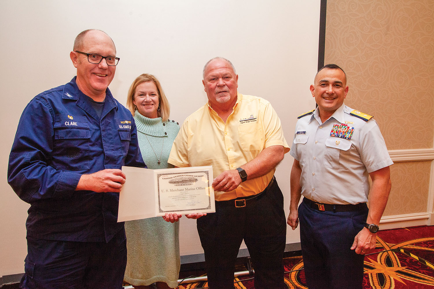 From left, Capt. Bradley Clare, Susan Dietz, Capt. Terry Dietz and Rear Adm. David Barata. Capt. Dietz was honored at the December meeting of the Marine Compliance Alliance. (Photo by Frank McCormack)