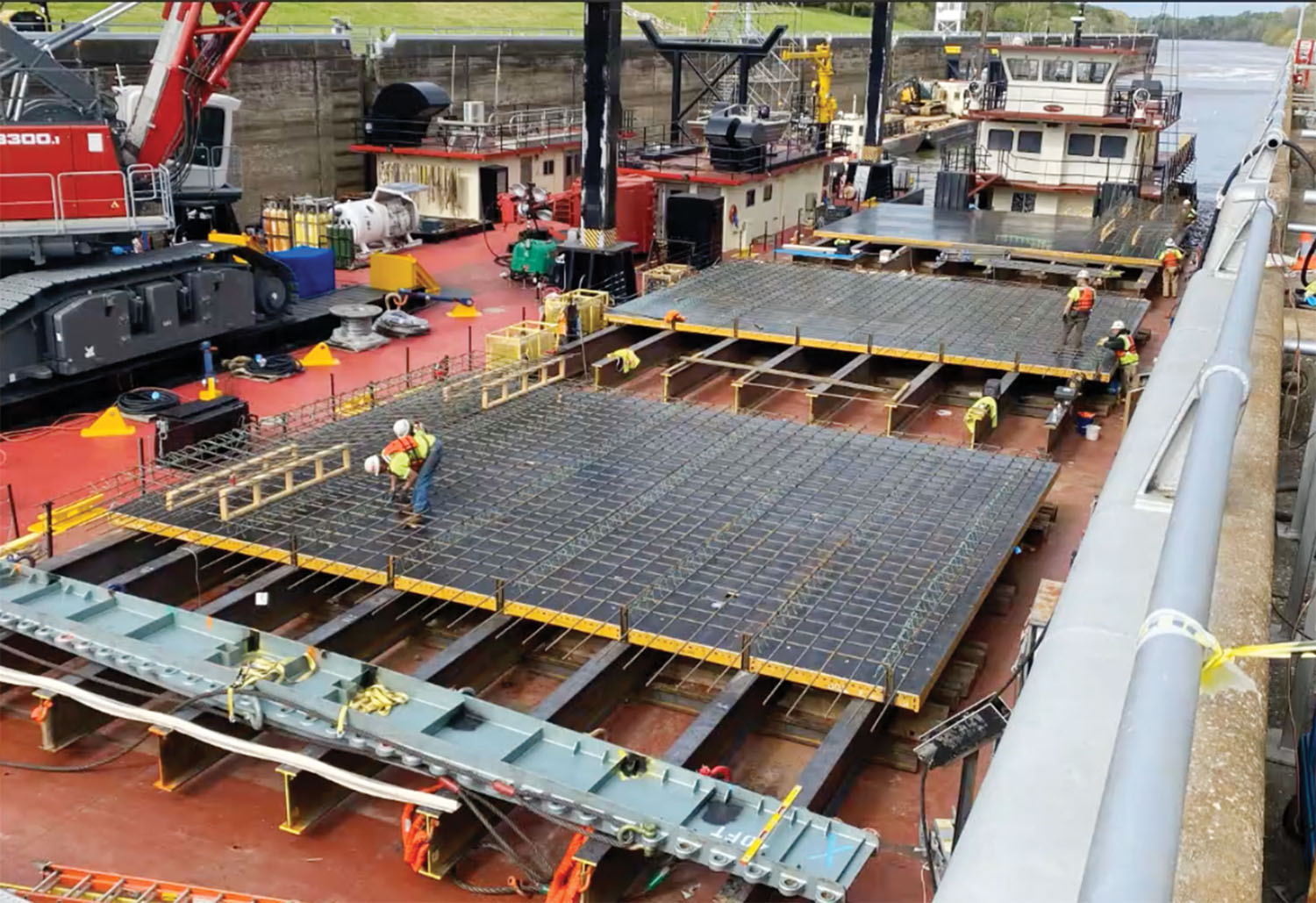 On a deck barge in the lock chamber, crews assemble forms that will eventually be lifted into the chamber to hold newly-poured concrete in place. (Photo courtesy of Mobile Engineer District)