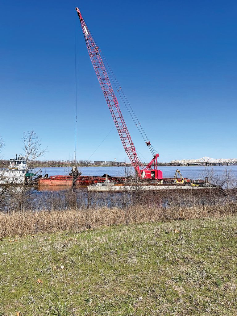 Crews work to offload coal from a partially submerged barge near the tip of Shippingport Island, on the Indiana bank. It was one of 10 that broke away from the tow of the mv. Amber Brittany on March 8. (Photo courtesy of Louisville Engineer District)
