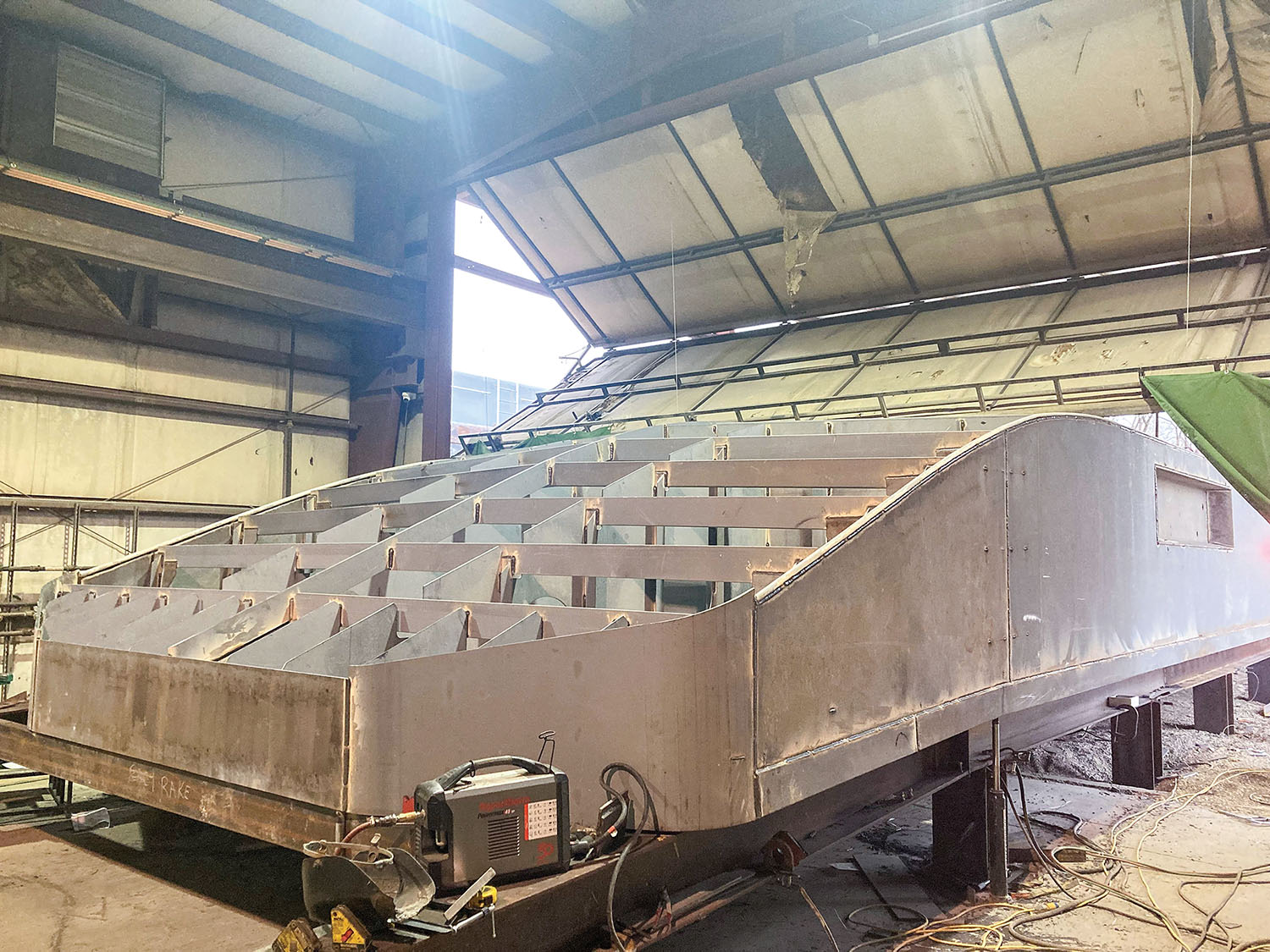 The hull for a boat that will be used for a ferry on the Tennessee River is under construction in the fabrication shop at Sheridan Shipyard, South Point, Ohio. (Photo courtesy of McGinnis Inc.)