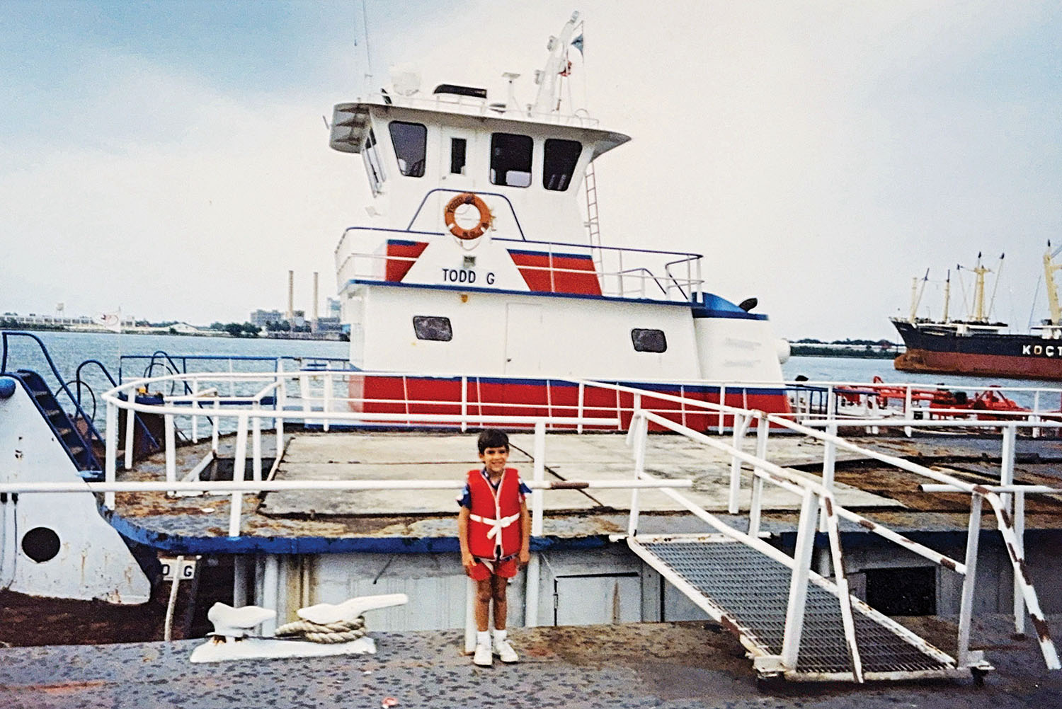 A 1980s photo of Todd Clower, now CEO of Harbor Towing & Fleeting, standing in front of his namesake vessel, the Todd G, docked at Star Fleet at Mile 91 on the Mississippi River in New Orleans.