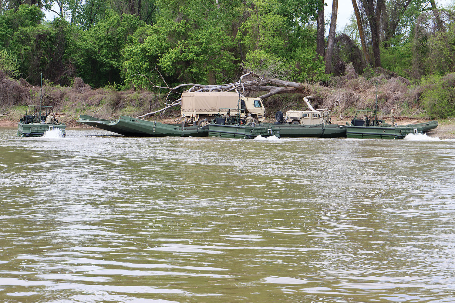 Army units perform a river assault and bridge-building exercise on the Arkansas River April 12. (Photo by Jay Woods, Rock Island Engineer District)
