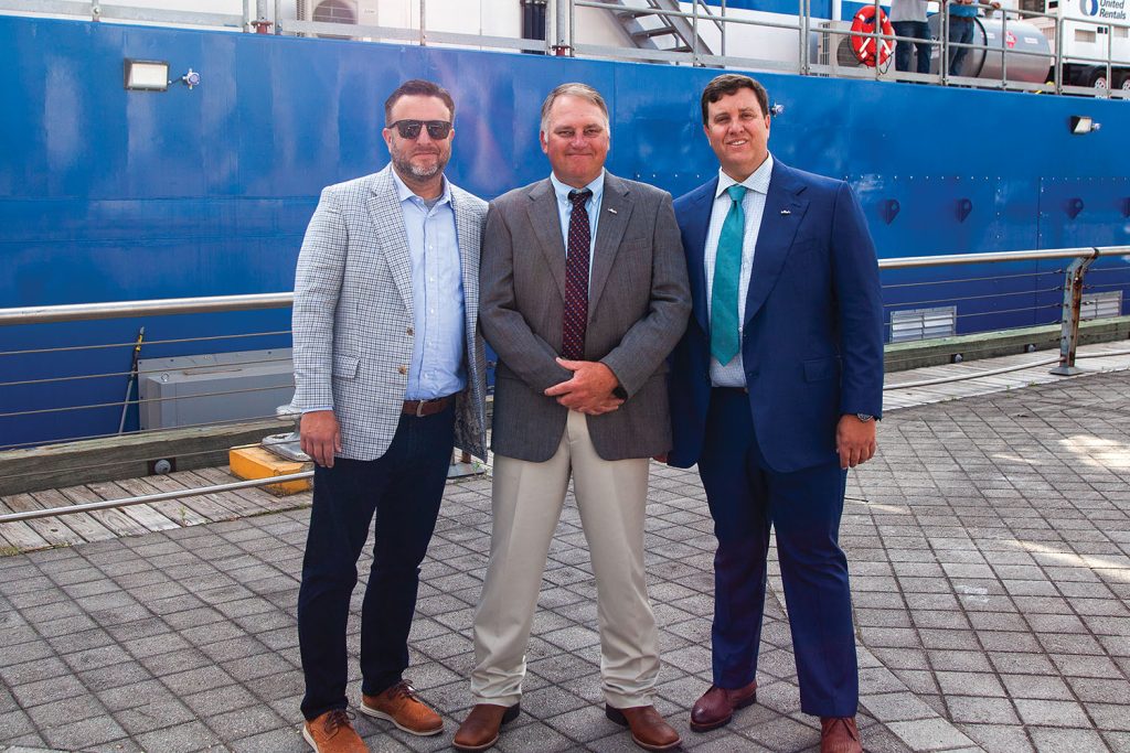 Mike Kerns (center), president, CEO and co-owner of Muddy Water Dredging, stands alongside company co-owner Matt Devall (right) and Devall’s brother, Kenny, CEO of Southern Devall. (Photo by Frank McCormack)