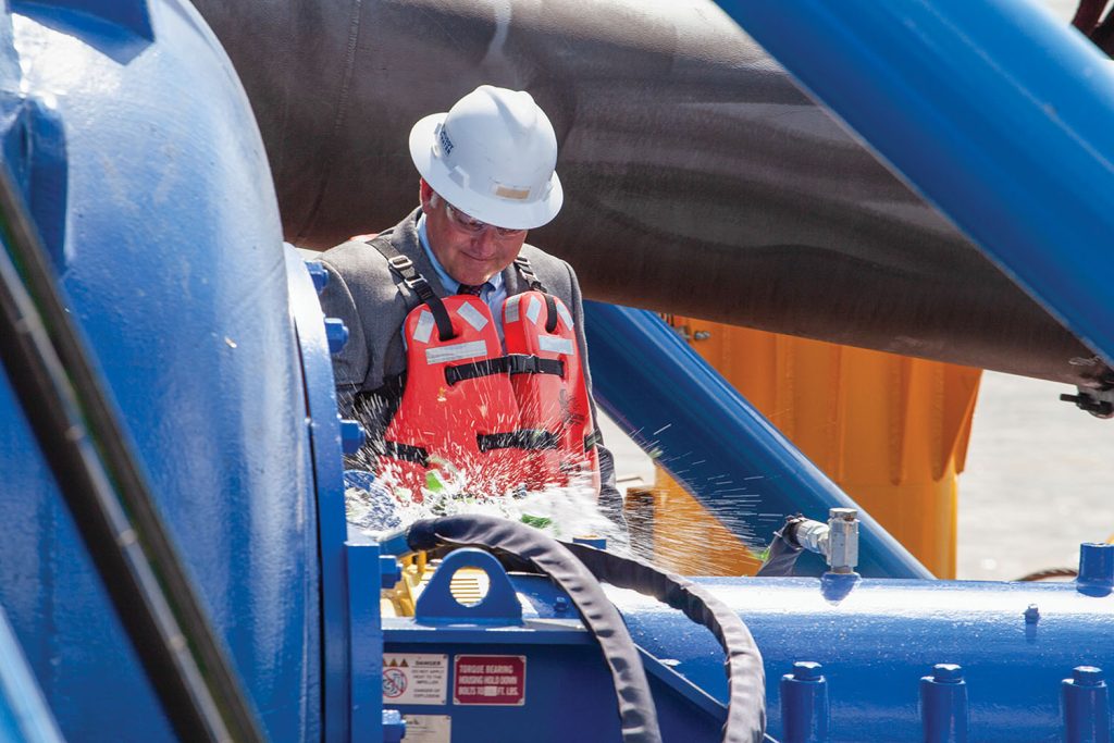 Mike Kerns, president, CEO and co-owner of Muddy Water Dredging, christens the cutter suction dredge Vaneta Marie, named for his mother. (Photo by Frank McCormack)