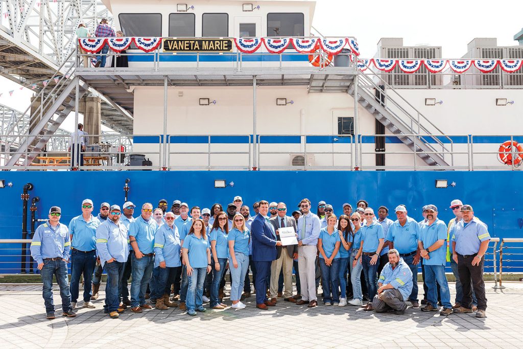 Muddy Water Dredging co-owners Matt Devall and Mike Kerns (center) stand with company employees in front of the cutter suction dredge Vaneta Marie on April 19 following the dredge’s christening ceremony. (Photo courtesy of Muddy Water Dredging)