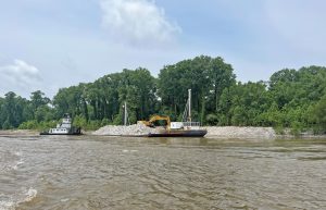 A contractor for the Memphis Engineer District places stone for a revetment on the Lower Mississippi River at Walnut Bend, near Helena, Ark. Midwest Construction Company of Nebraska was the contractor, and Luhr Crosby LLC of Columbia, Ill., was the subcontractor for the $1.5 million project that included two stone revetments. (Courtesy of the Memphis Engineer District)