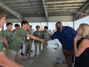 Crescent River Pilot Capt. Roy Vance, VP Marketing and Public Relations works with students at the Soft Skills Elevator Pitch station, where students learn how to make the best first impression.