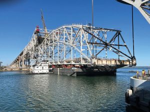 The center span of the Old Harbor Bridge was lowered onto the Prometheus, a 300-foot by 100-foot barge operated by Canal Barge Company, for transport.
