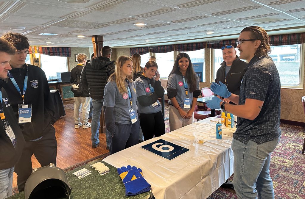 Heartland Fabrication engages with students at the company’s station at the WWW event in Pittsburgh. Students learned about welding and participated in an activity “welding” crackers together with spray cheese. (Photo courtesy of the Waterways Association of Pittsburgh)