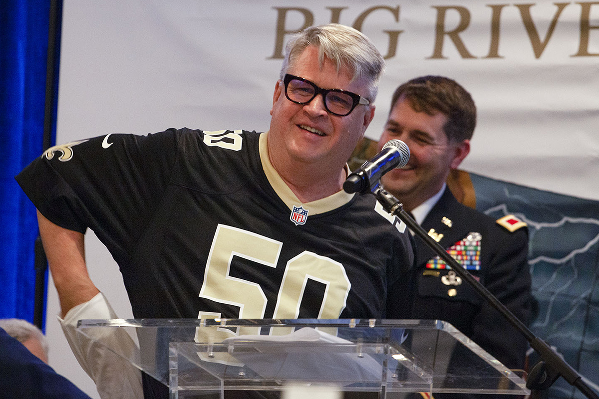 Sean Duffy, speaking at an August 16, 2022, celebration for the deepening of the Mississippi River Ship Channel to 50 feet, reveales a number 50 New Orleans Saints jersey. Former New Orleans District commander Col. Stephen Murphy is pictured in the background. (Photo by Frank McCormack)