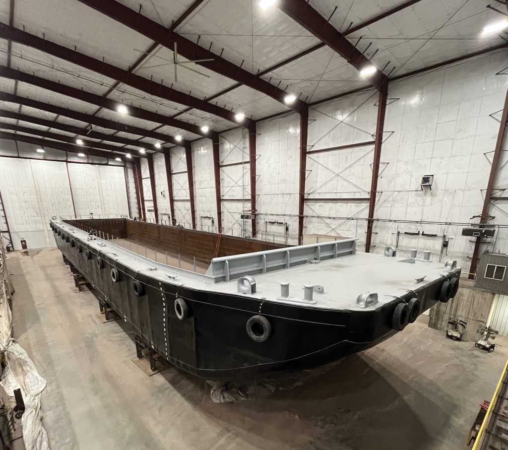 Carver Marine Steel Works’ indoor repair facility houses a barge positioned inside the building, where the company can handle barge repair and retrofit work under cover.
