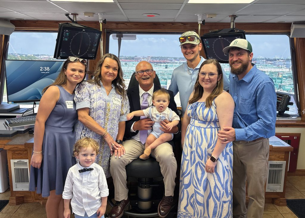 Capt. Joey Anderson, seated, poses with family members in the wheelhouse before christening the vessel named after him. Two of Anderson’s sons (wearing Blessey hats) also work for the company.