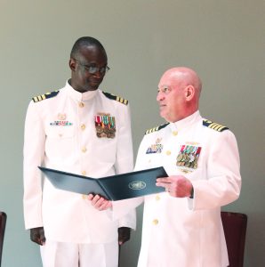 Capt. Randy Preston, commander of Coast Guard Sector Ohio Valley (right), reviews Cmdr. Shehu Bello’s Award of Meritorious Service during the command change ceremony June 9 for Marine Safety Unit Paducah. (Photos by Shelley Byrne)