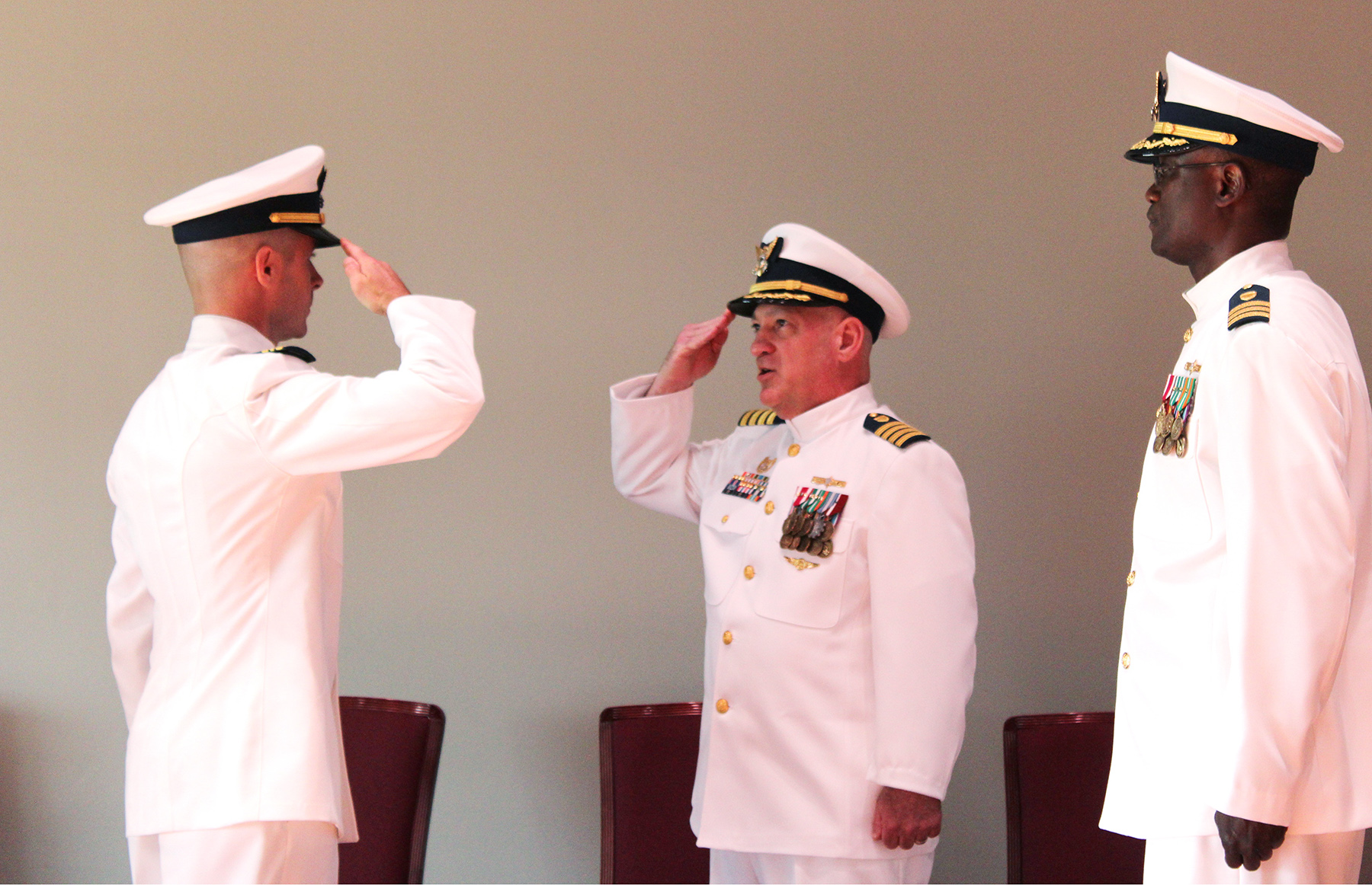 260615_MSU Paducah command change Lt. Cmdr. Daniel Wilkinson, incoming commander of the Coast Guard’s Marine Safety Unit Paducah (left), and Capt. Randy Preston, commander of Coast Guard Sector Ohio Valley (center), salute each other during the change of command ceremony as outgoing commander Cmdr. Sheu Bello (right) looks on.