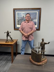 Randy Mayse poses with several of his handcrafted bronze sculptures and shares the stories and inspiration behind his work during the interview. (Photo by Nelson Spencer, Jr.)