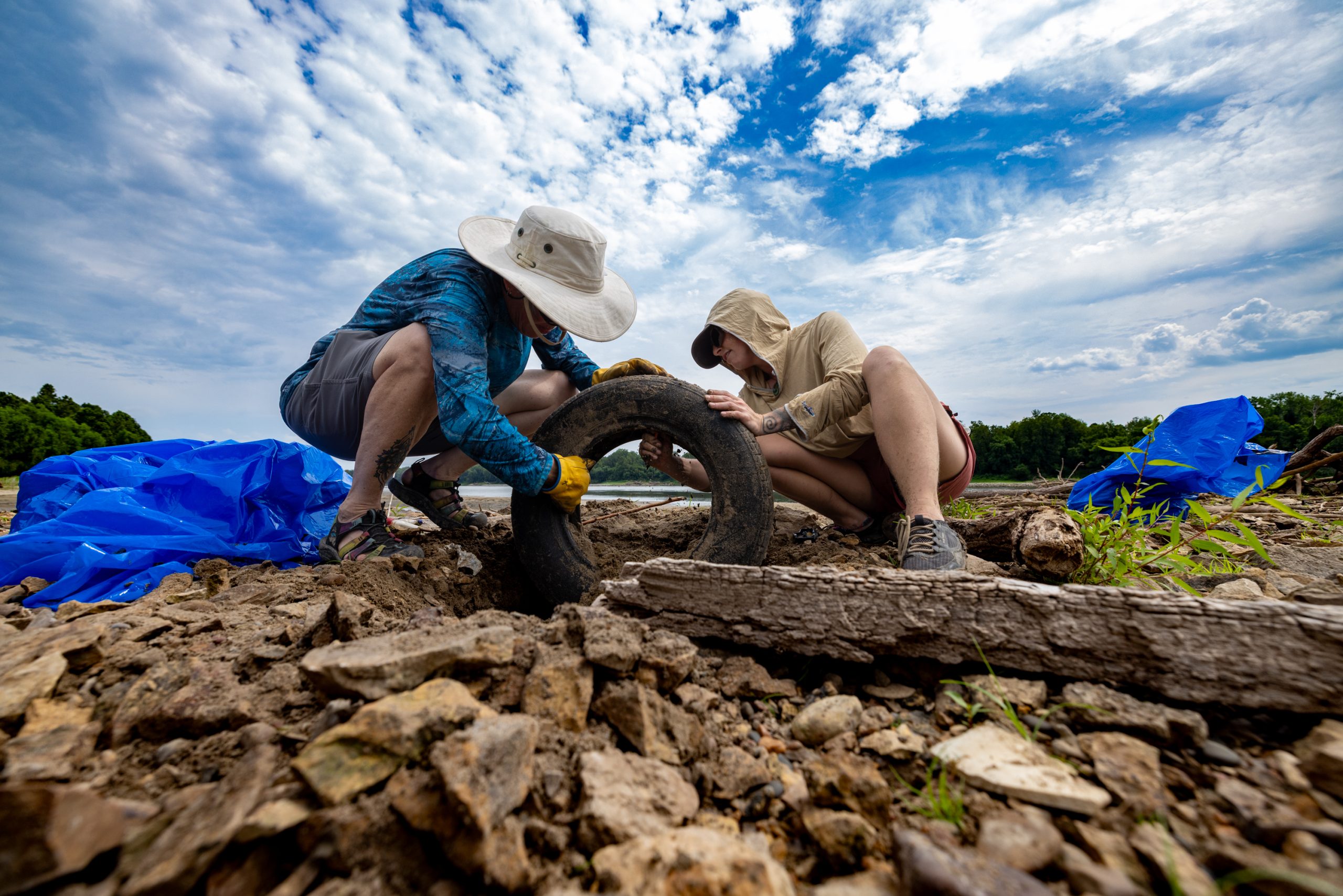 Missouri River Relief volunteers remove a discarded tire from the banks of the Missouri River during a Big Muddy Clean Sweep cleanup. The annual cleanup brings volunteers together to remove debris and help protect the river and its surrounding environment. (Photo credit to Missouri River Relief)