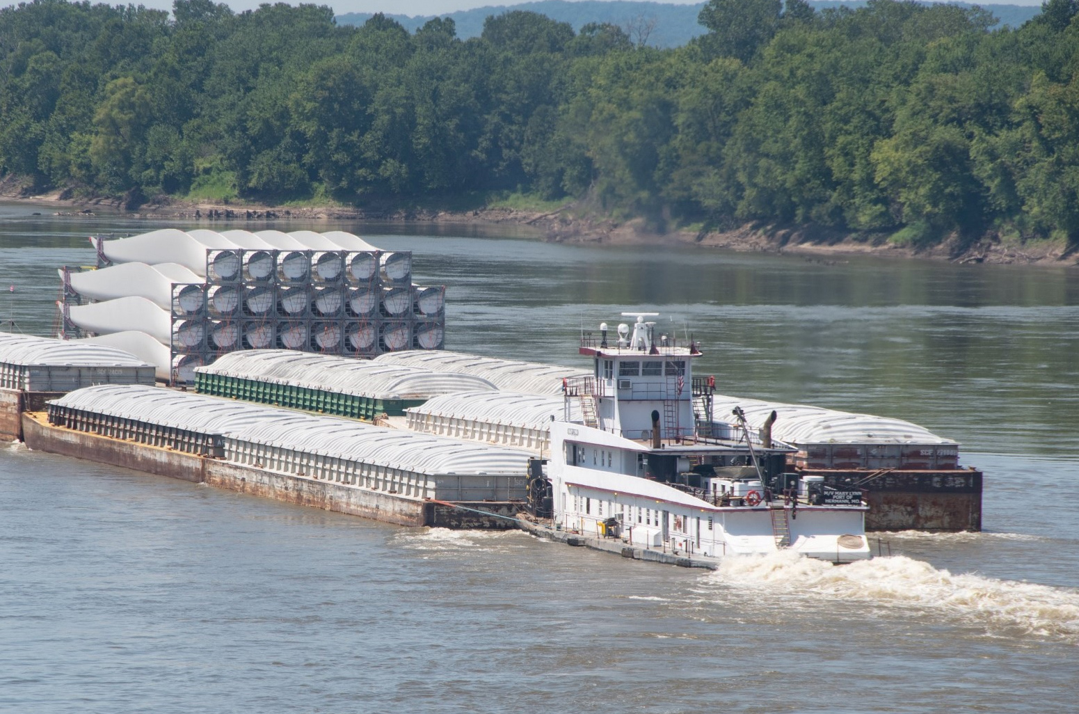 An MRT towboat with barges and heavy cargo in tow moves on the Missouri River. The company operates four line-haul vessels and is considering adding a fifth in 2027. (Photo courtesy of Missouri River Towing)