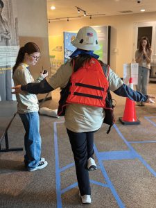 Brandon Phillips, compliance and human resources manager at Riverview Companies, leads students through a taped visualization of elements they might encounter in the river, including dikes, a lock and dam and drift piles. (Photos by Amber McClay)